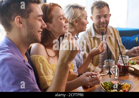 Schöne kaukasische Männer und Frauen halten freundliche Treffen im Café, sie haben eine tolle Zeit nach der Arbeit, haben Gespräch. Freizeit, Getränke, Menschen und communicati Stockfoto