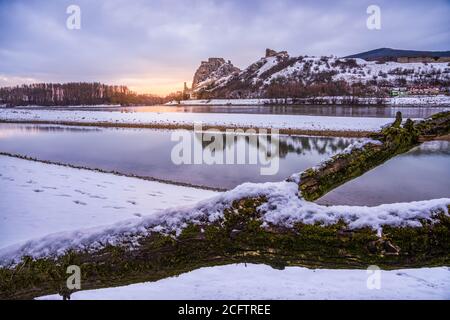 Schneebedeckte Ruinen der Burg Devin über der Donau in Bratislava, Slowakei bei Sonnenaufgang Stockfoto