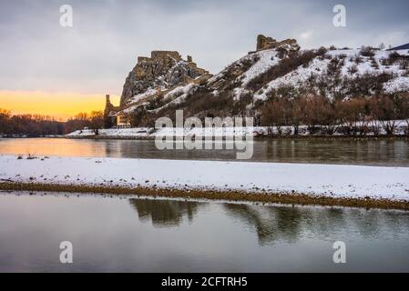 Schneebedeckte Ruinen der Burg Devin über der Donau in Bratislava, Slowakei bei Sonnenaufgang Stockfoto