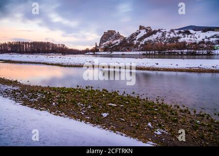 Schneebedeckte Ruinen der Burg Devin über der Donau in Bratislava, Slowakei bei Sonnenaufgang Stockfoto