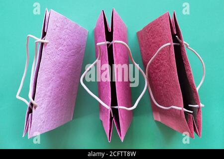 Bunte strukturierte Papier Einkaufstaschen auf Minze Hintergrund. Minimaler Mode-Shopping Online-Konzept. Draufsicht, Stockfoto