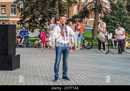 Dnipro, Ukraine - 21. August 2020: Der Mann mittleren Alters Prygunov Glib in Nationaltracht spricht ins Mikrofon auf dem zentralen Platz der Stadt Stockfoto