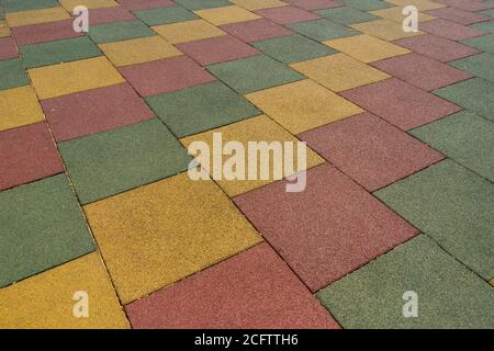 Farbige Gummi quadratische Pflasterplatte für Spielplätze Nahaufnahme. Stockfoto