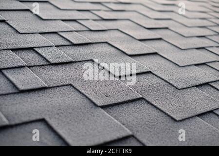 Nahaufnahme auf Asphalt Roofing Schindeln Hintergrund. Dachschindeln - Dacheindeckung. Dachschindeln mit Frost bedeckt Stockfoto