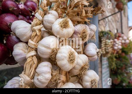 Ein Bündel getrockneten Knoblauchs, der draußen an einer Wand hängt Stockfoto