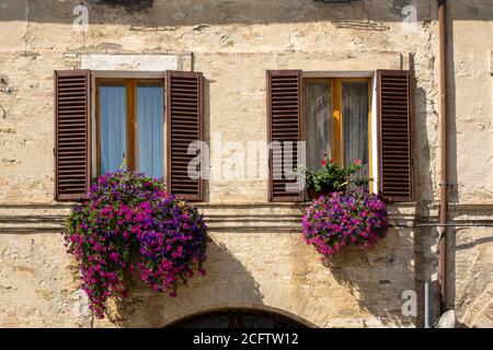 Italienisches Fenster mit hölzernen Fensterläden in einer Ziegelwand Stockfoto