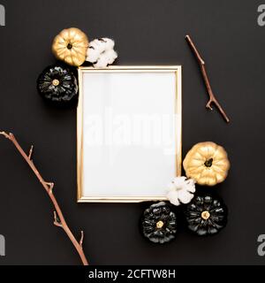 Goldrahmen verziert mit schwarzem und goldenem Halloween Kürbis mit Platz für Text. Isoliert auf schwarzem Hintergrund. Flach liegend, Draufsicht. Stockfoto