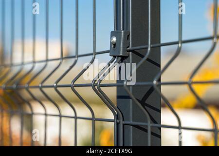 Stahlgitter Zaun mit Draht auf blauem Himmel Hintergrund gemacht. Montage der Abzäunung Stockfoto