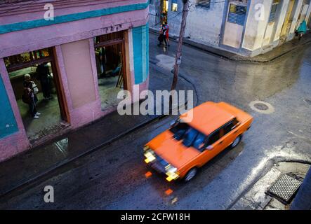 SANTIAGO DE CUBA, KUBA - CA. JANUAR 2020: Typische Straßenszene in Santiago de Cuba an einem regnerischen Tag. Stockfoto