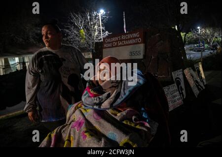 Sacramento, Kalifornien, USA. Februar 2020. FELICIA BRENT-VELASQUEZ, 18, wird in ihrem Rollstuhl in Decken gebündelt, als sie sich ihrer Mutter FELICIA CLARK, 36, aus Protest vor dem Kinderempfangsheim von Sacramento anschließt. "Es ist schwer, die Dinge zu sehen, die ich da draußen sehe, aber deshalb gehe ich immer wieder zurück", sagte Clark. "Ich will nur einen Freitag da draußen stehen und nichts sehen. Ich möchte keine Kinder sehen, Menschen tun, was sie tun sollen, Kinder gehen, um Aktivitäten zu machen, Eltern kommen und glücklich, Teil eines Prozesses zu sein." (Bild: © Renee C. Byer/Sacramento Stockfoto