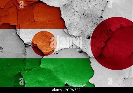 Flaggen von Niger und Japan auf rissige Wand gemalt Stockfoto