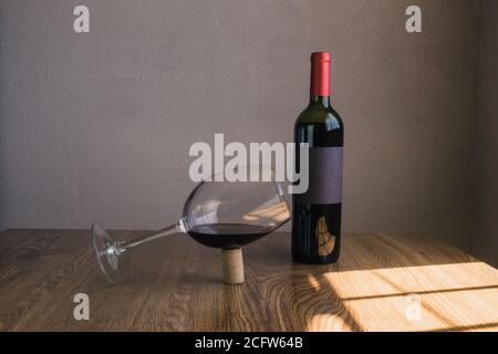 Ausgewogenes Weinglas in Kork neben Weinflasche. Mockup der Weinflasche Stockfoto