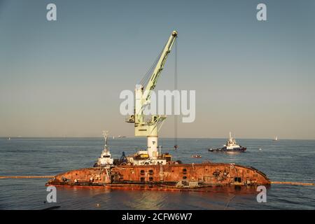 Rettungswrack Öltanker Delfi in Odessa, Ukraine 26 August 2020, in der Nähe der Schwarzmeerküste. Marine Crane lift Wrack Delphi ins Meer. Alte rostige Schiff liegen Stockfoto