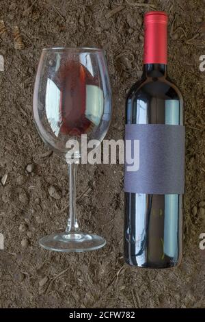 Weinflasche Mockup neben einem Rotwein Glas in Fruchtbares Weinbergland Stockfoto