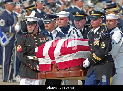 Eine kombinierte UNS militärische Ehrengarde trägt der 40. Präsident der Vereinigten Staaten Ronald Wilson Reagan in seiner Flagge - drapierte Schatulle zu einem leichenwagen Für eine Beerdigung Prozession nach seiner Ankunft an der Andrews Air Force Base (AFB), Maryland (MD), die an Bord der Air Force One. Stockfoto
