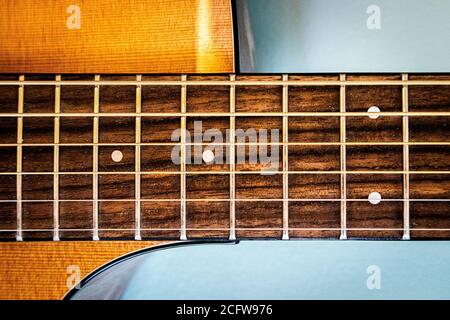Nahaufnahme von 6 Saiter Gitarre Griffbrett und Zederndecke Auf blauem Hintergrund Stockfoto