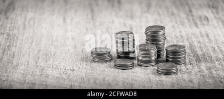 Stapel alter Groschen auf einem Holztisch in Schwarz Und weiß Stockfoto