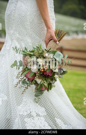 Braut mit einem Blumenstrauß aus einheimischen australischen Blumen Stockfoto