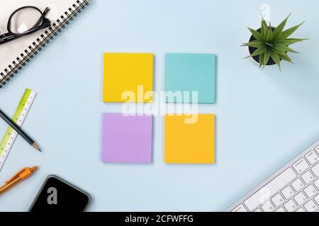 4 Haftnotiz oder Notizblock und Bürobedarf als Tastatur, Stift, Bleistift, Büropflanzen, Spiral-Notebook, Brille, Lineal, Handy auf Modern Clean Creative Stockfoto