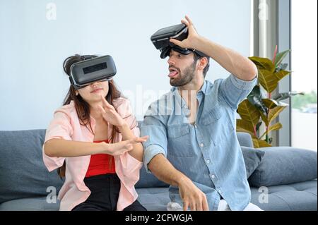 Paare Liebhaber genießen es, VR-Spiel zusammen zu Hause zu spielen. Familienbeziehungskonzept. Stockfoto