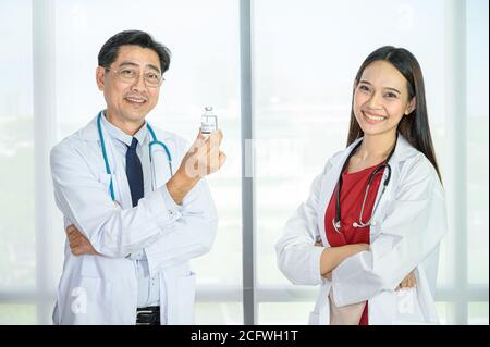 Paar asiatische Erwachsene männlichen Arzt und asiatische junge weibliche Arzt trägt formelle weiße Mantel Teamarbeit Brainstorming Treffen im Krankenhaus. Gesundheitsfürsorge Stockfoto