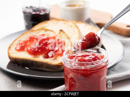 Bild Foto von einem Brot und Marmelade Frühstück. Nahaufnahme der Marmelade mit einem Löffel geschöpft Stockfoto