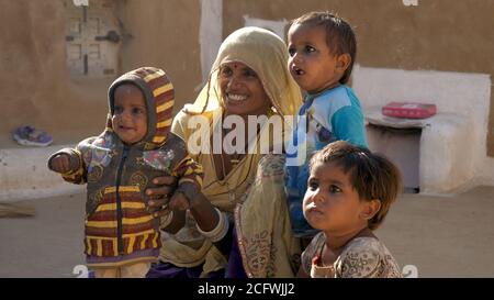 Jaisalmer, Indien - 20. Dezember 2017: Lächelnde Mutter mit drei Kindern. Stockfoto