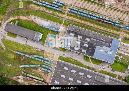 Straßenbahndepot in der Stadt. Straßenbahnen, Straßenbahnschienen und Industriegebäude. Luftaufnahme von oben von fliegender Drohne Stockfoto