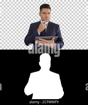 Junger Geschäftsmann mit Blick auf Tablet und Denken, Alpha Channel Stockfoto