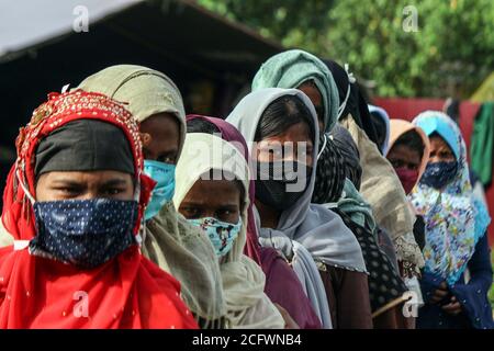 Lhokseumawe, Indonesien. September 2020. Rohingya-Frauen, die Masken tragen, werden in einer Warteschlange gesehen, um sich medizinischen Untersuchungen und Schnelltests in einem temporären Tierheim in Lhokseumawe zu unterziehen.Fast 300 ethnische Rohingya-Muslime waren in den Gewässern des Aceh-Meeres gestrandet. Bestehend aus Erwachsenen und Kindern, die aufgrund von Austrocknung und Hunger schwach sind, nachdem sie auf hoher See beeinflusst wurden. Kredit: SOPA Images Limited/Alamy Live Nachrichten Stockfoto