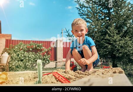 Niedliche Babyjungen spielen mit Sand in einer sandbox Stockfoto