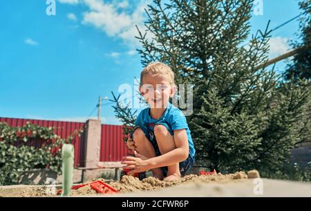 Niedliche Babyjungen spielen mit Sand in einer sandbox Stockfoto