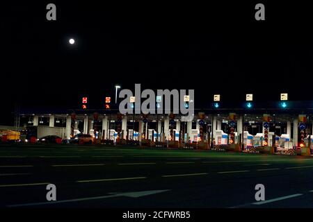 Autotransport auf mehrspurigen Autobahn Straße und Mautentor, Drohne Antenne Draufsicht in der Nacht. Pendlerverkehr, City Life Konz Stockfoto