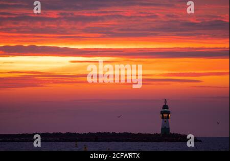 Mukran, Deutschland. September 2020. Vor Sonnenaufgang blitzt das Leuchtfeuer am Pier in Mukran auf der Insel Rügen. Von Mukran aus werden die Vorbereitungen für den weiteren Bau der Nord Stream 2 Ostsee-Pipeline getroffen. Quelle: Jens Büttner/dpa-Zentralbild/dpa/Alamy Live News Stockfoto