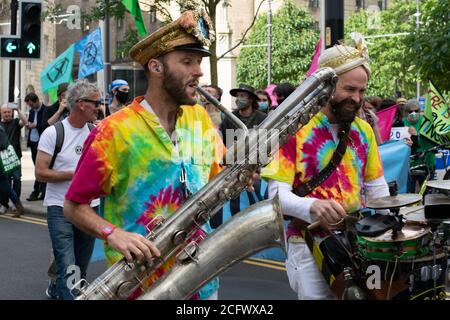 Extinction Rebellion Protest, Manchester, Großbritannien. Die stille Rebellion Parade, angeführt von Herrn Wilsons zweiten Linern. Saxophonist bei der Parade. Stockfoto