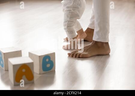 Barfuß afrikanisch amerikanische Frau unterrichtet kleine biracial Baby Kind zu Fuß. Stockfoto