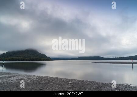 Ein nebliger Start in den Tag mit Wolken über dem Fluss und Inseln in Mooney Mooney am Hawkesbury River, Central Coast, NSW, Australien Stockfoto