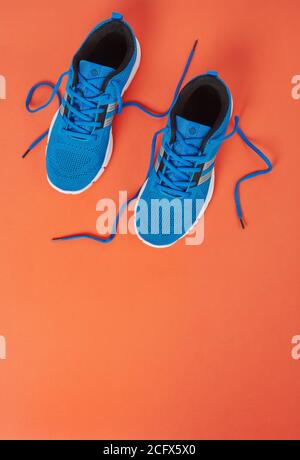 Blaue Sportschuhe auf orangefarbenem Hintergrund Stockfoto