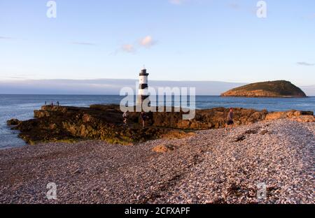 Der historische Leuchtturm an der Penmon Bay in Anglesey schützt die Schifffahrt Auf den Fahrspuren zu den Docks von Liverpool und Lokales Vergnügungsschiff aus dange Stockfoto