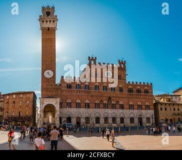 Schöner Blick auf das berühmte Rathaus Palazzo Pubblico mit dem kompletten Glockenturm Torre del Mangiaa, an einem sonnigen Tag auf der historischen Piazza del Campo... Stockfoto