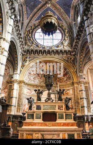 Große Nahaufnahme des aus Marmor gegossenen Hochaltars mit einem großen bronzenen eucharistischen Tabernakel im Presbyterium der berühmten Kathedrale von Siena. Der Hauptaltar Stockfoto