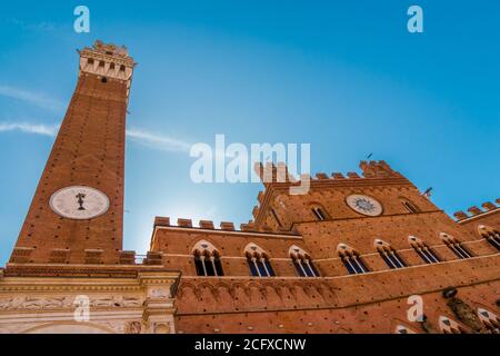 Schöne Nahaufnahme des mittelalterlichen Rathauses Palazzo Pubblico mit dem Glockenturm Torre del Mangiaa, in der historischen Piazza del Campo auf einem... Stockfoto