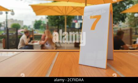 Die Auftragsnummer auf dem Tisch in einem McDonald's-Restaurant auf der Straße. Warten auf eine Bestellung in einem McDonald's-Restaurant. Fastfood mit Rechnung, Scheck. U Stockfoto