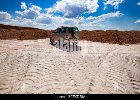 Aluminiumerz Bergbau und Transport. Steinbruch aus Bauxit. Offroad-Auto auf blauem Himmel mit Wolken Hintergrund. Stockfoto