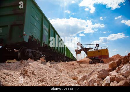 Aluminiumerz Bergbau und Transport. Bauxit Tonerde Tagebau. Elektrobagger Verladung Erz in Trichter Auto Zug. Stockfoto