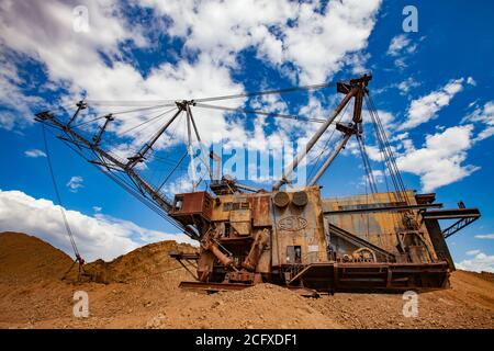 Aluminiumerz Bergbau und Transport. Bauxit Tonmine. Alte verrostete Draglinienbagger im Steinbruch. Am blauen Himmel mit Wolken. Stockfoto