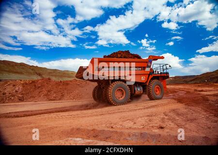 Aluminiumerz Bergbau und Transport.. Tagebau (Steinbruch). Orange Hitachi Steinbruch Kipper mit Bauxit Ton. Stockfoto