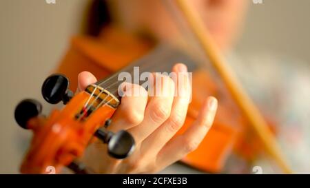 Junge Frau spielt Geige. Hände des Musikers, Nahaufnahme. Vorderansicht. Stockfoto