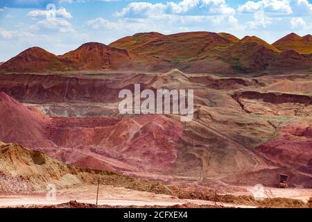 Farbe Aluminium Erz Steinbruch. Bauxit Tagebau (Open Cast). Haufen von Mineralien und leerem Gestein. Am blauen Himmel mit Wolken. Stockfoto