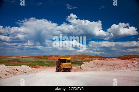 Aluminiumerz-Steinbruch (Bauxit-Mine). Tagebau. Steinbruch Kipper BELAZ auf weißer Straße und blauen Himmel mit Wolken Hintergrund. Stockfoto